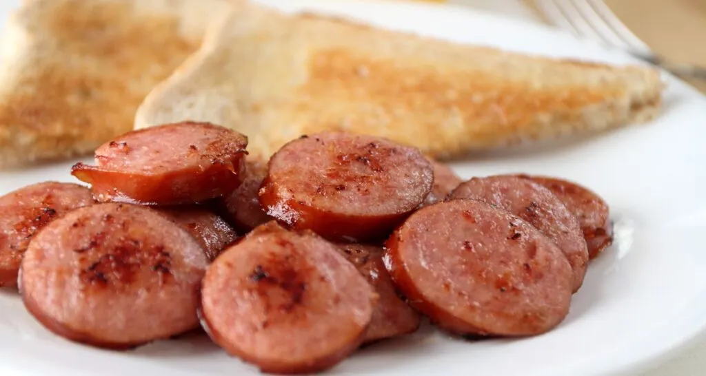 Slicing smoked kielbasa sausage for a family dinner